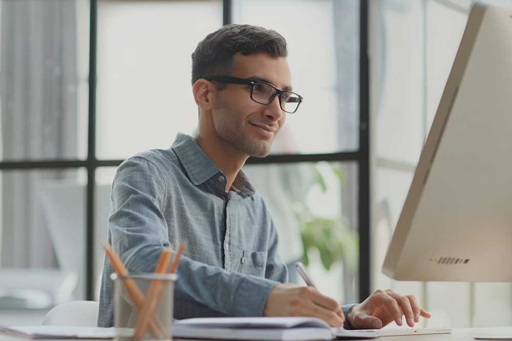 Mann mit Brille am Arbeitsplatz, übersetzt technische Dokumentation mit Hilfe von LinguaCraftAI